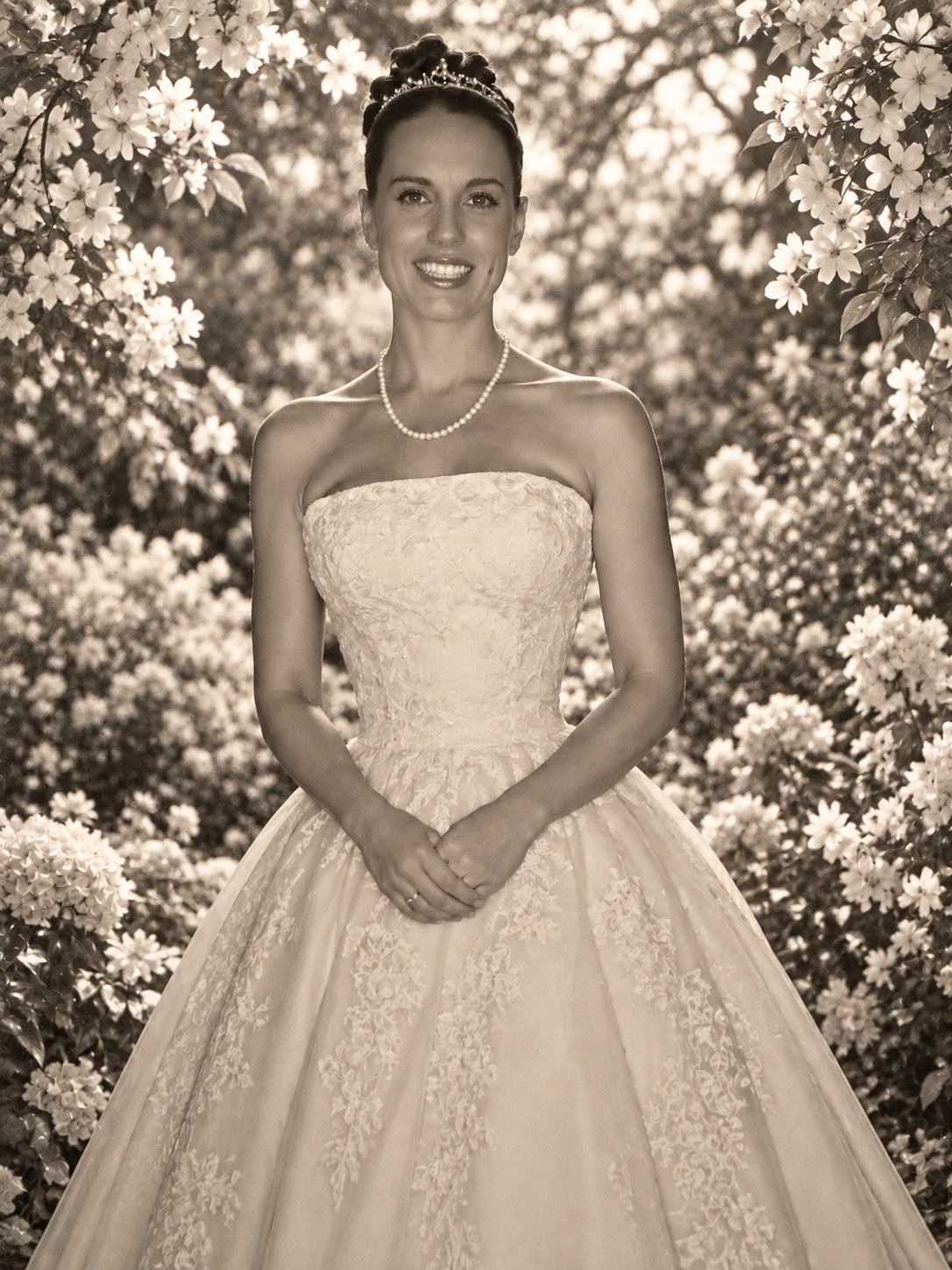 Lisa Jane in a floral setting, wearing a tiara and white gown